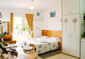 Un dormitorio con una cama y una mesa. en Apollonia Hotel Apartments, en Pafos