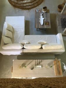 - un canapé blanc avec des oreillers sur une table dans l'établissement Uzes, loft dans Moulin independant 18e siecle en bord de riviere piscine privee 15x3, à Uzès