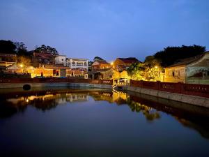a river at night with houses and a bridge at PianoPiano B&B in Jincheng +29 photos
