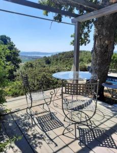 een tafel en stoelen op een patio met een boom bij casa intera giardino e piscina in Tuoro sul Trasimeno