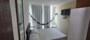 um quarto de hospital com uma cama e uma janela em Suites Jangadeiro Maragogi 1 RUA JANGADEIROS 215 em Maragogi
