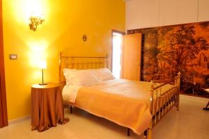 - une chambre avec un lit dans une pièce jaune dans l'établissement Bed & Breakfast La dodicesima Notte, à Viggiano