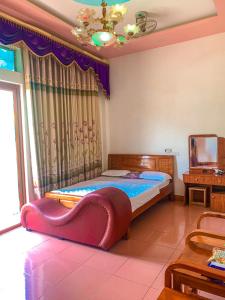 a bedroom with a bed with a heart shaped couch at Khách Sạn Cương Thảo in Ha Giang