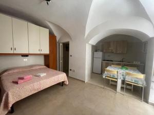 ヴィエステにあるDimora Nel Borgoのベッド2台とキッチンが備わる小さな客室です。