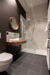 a bathroom with a shower and a toilet and a sink at Vinotel X in Tongeren