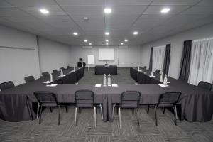 uma sala de conferências com uma grande mesa e cadeiras em BON Hotel Rustenburg em Rustenburg