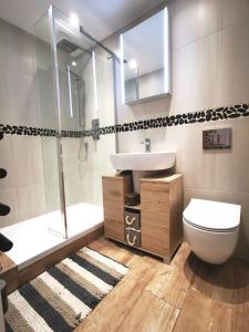 a bathroom with a toilet and a sink and a shower at Apartment in the heart of East Wittering Village in Chichester
