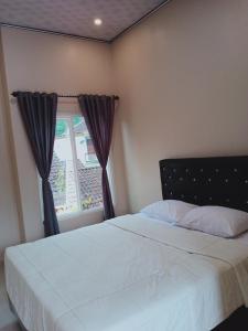 a bedroom with a white bed and a window at VILLA PRINGGITAN in Karanganyar +8 photos