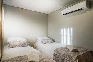 a small room with two beds and a air conditioner at Hotel Fazenda Terra dos Sonhos in Bueno Brandão