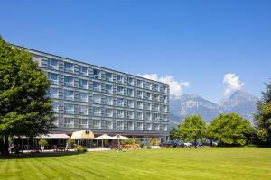 un hotel con césped frente a un edificio en Hotel Vatel 4* Superior, en Martigny-Ville