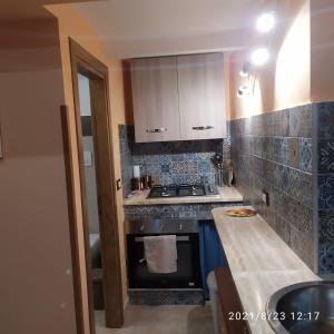 a kitchen with a stove top oven next to a counter at STONE HOUSE e Casa Vacanze Zia Rosina in Montemaggiore Belsito +42 photos