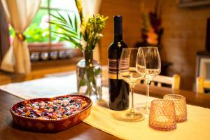 einen Tisch mit einer Flasche Wein und zwei Gläsern in der Unterkunft SOVIA WELLNESS CHATA s jacuzzi kaďou a saunou, Čingov in Smižany