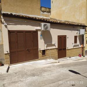 a building with brown doors and a speaker on it at STONE HOUSE e Casa Vacanze Zia Rosina in Montemaggiore Belsito