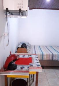 um pequeno quarto com uma mesa e uma cama em Infinito Suíte em São Paulo