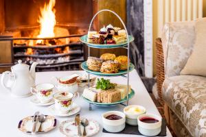 a display of pastries and tea on a table with a fireplace at Eshott Hall in Morpeth