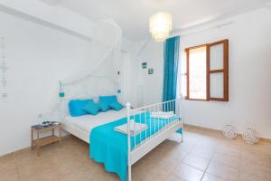 a white bedroom with a bed and a window at Old Town Roloi House in Rhodes Town