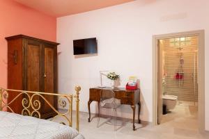 1 dormitorio con cama, escritorio y aseo en B&B San Marco - Porta Maggiore, en Ascoli Piceno