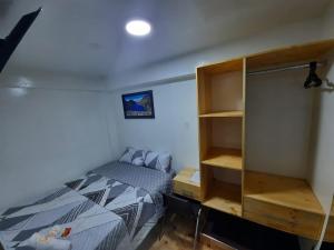 1 dormitorio con cama y estante para libros en Hostal Estrellas, en Huaraz