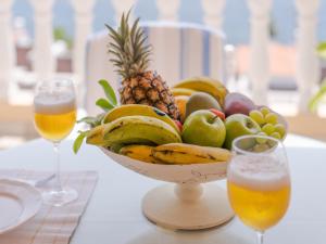 a bowl of fruit on a table with two glasses of beer at Casa Laura in Puerto de Santiago