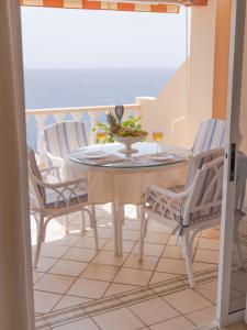 a table and chairs on a balcony with a view of the ocean at Casa Laura in Puerto de Santiago