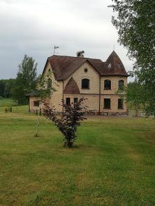 an old house in a field with a tree at Vesta in Dolnāja +12 photos