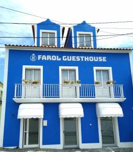 un edificio azul con ventanas y balcones blancos en Farol Guesthouse, en Angra do Heroísmo