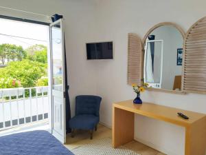 a bedroom with a desk and a mirror and a chair at Farol Guesthouse in Angra do Heroísmo