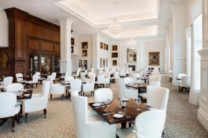 une salle à manger avec des tables et des chaises blanches dans l'établissement The Equestrian, à Ocala