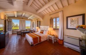 a bedroom with a bed and a living room at Borgo Scopeto Wine & Country Relais in Vagliagli