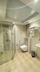 a bathroom with a shower and a toilet and a sink at Alsahwa Hotel in Seeb