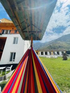 a pile of colorful hammocks in front of a house at Hotel NOA Kazbegi in Stepantsminda