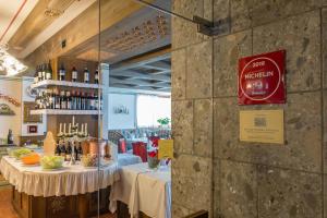 a restaurant with two tables with bottles of wine at Hotel Alla Posta - Famiglia Pra dal 1866 a Caprile in Alleghe