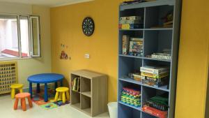 ein Kinderzimmer mit einem Bücherregal und einem Stuhl in der Unterkunft Albergue Internacional de Llanes in Llanes
