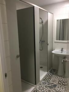 a bathroom with a shower and a sink at Albergue Internacional de Llanes in Llanes +17 photos
