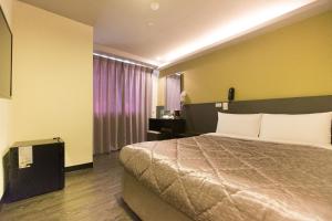a hotel room with a bed and a window at Chance Hotel in Taichung
