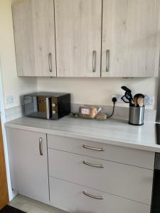 a kitchen counter with a microwave on top of it at 8 Thoms Street in Kirkwall