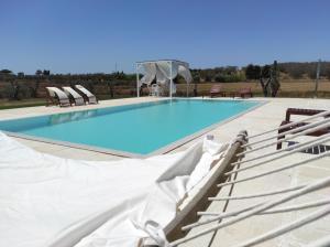 a swimming pool with two chairs at Masseria Vignenove in Uggiano la Chiesa