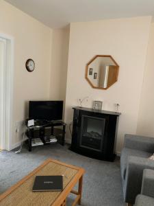 a living room with a fireplace and a mirror at 8 Thoms Street in Kirkwall