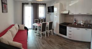 a kitchen and a living room with a couch and a table at Apartments Villa Anna in Podstrana