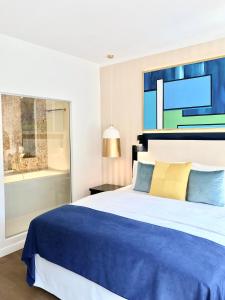 Schlafzimmer mit einem blauen und weißen Bett und einem Fenster in der Unterkunft Luxury Apartments MONDRIAN Market Square III in Warschau