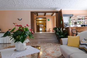 a living room with a vase of flowers on a table at Hotel Rosa Del Tirreno in Quercianella