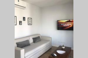 sala de estar con sofá y TV en la pared en Departamento a estrenar, Palermo Hollywood V en Buenos Aires