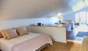 ヴィーラ・フランカ・ド・カンポにある374 CK Seaside Guest Houseのベッドルーム1室(ベッド1台、ランプ付きテーブル付)