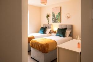 a room with two beds and a couch in it at Emerald Court Executive Watford Central Apartment by PAY AS U STAY in Watford