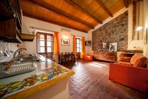 a kitchen and living room with a stone wall at B&B Il Padrino in Savoca