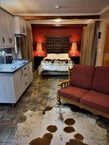 1 dormitorio con cama, sofá y lavamanos en Blessings Guesthouse, en Newcastle