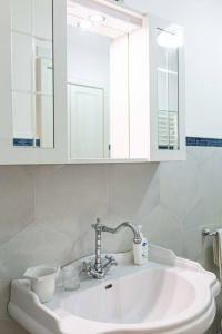a white sink in a bathroom with a mirror at Pink liberty house in Santa Croce Camerina