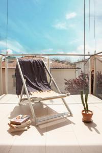 una poltrona sul balcone con cactus di Residence Sunrise Cesenatico a Cesenatico