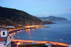 een stad met een brug over een waterlichaam bij Apartamento Vista do Mar A in Ribeira Quente