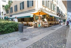 a street with tables and chairs in front of a building at Brera Vicolo Fiori in Milan